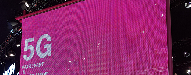 Mikä on 5G? Valkokangas, jolla teksti 5G pinkkiä taustaa vasten.
