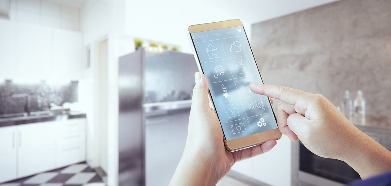 Hallitse älykkäitä kodinkoneita Home Connect -sovelluksella Kädet pitelevät älypuhelinta keittiössä.