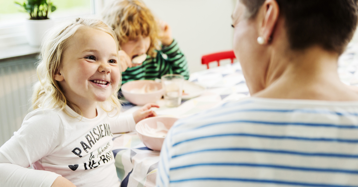 Miksi kannattaa valita varsi-imuri? Äiti ja kaksi lasta istuvat ruokapöydän ääressä.