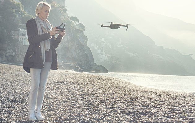 Näe maailma uudesta kulmasta Naishenkilö, joka lennättää dronea rannalla