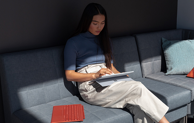 Käytä Surface Pro 7 -laitetta omalla tavallasi Nainen istuu sohvalla ja käyttää Surface Pro 7 -laitetta