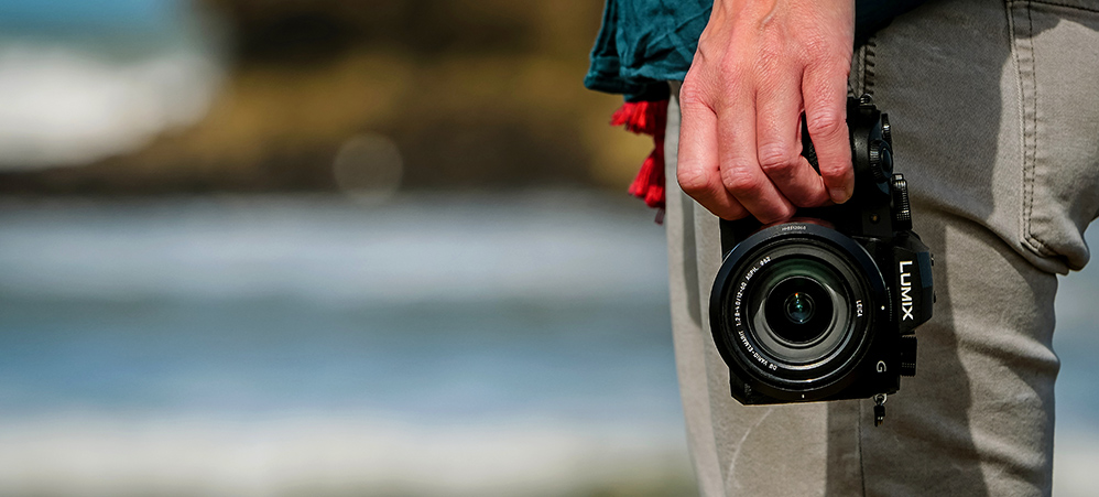 Panasonic LUMIX G90 Käsi pitelee mustaa G90-kameraa