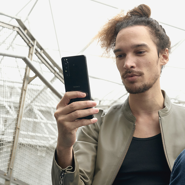 Nauti 5G-verkon eduista Nuori mies pitelee Sony Xperia 1 II -puhelinta kädessään