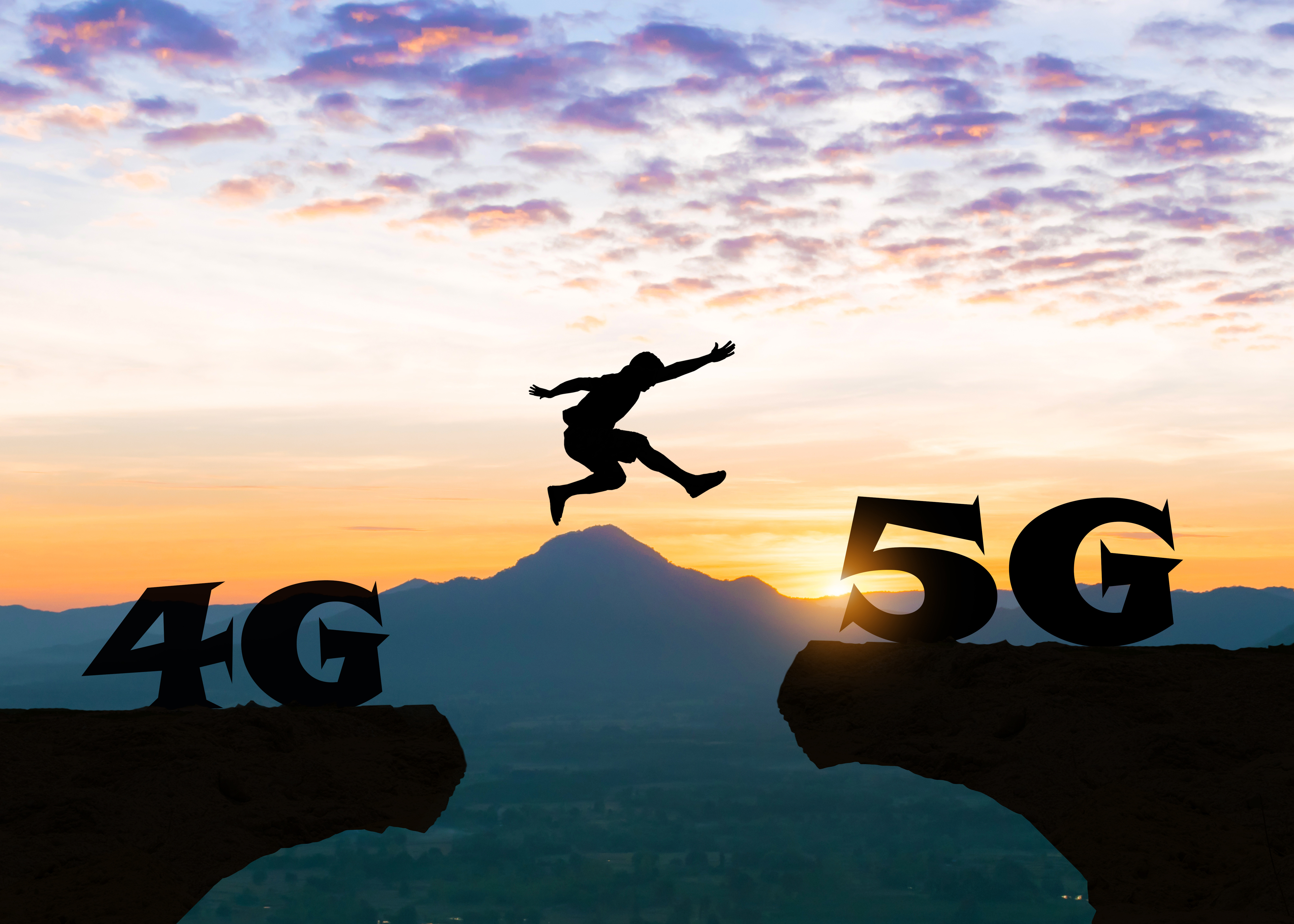 5G-verkko Mies hyppää kallion kielekkeeltä toiselle. Kallioilla 4G ja 5G -symbolit