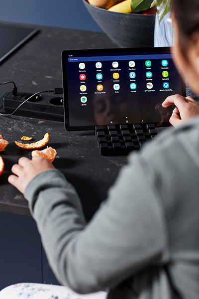 Epoq Trend Blue Grey -keittiö Lapsi istuu keittiösaarekkeen ääressä ja käyttää tablettia