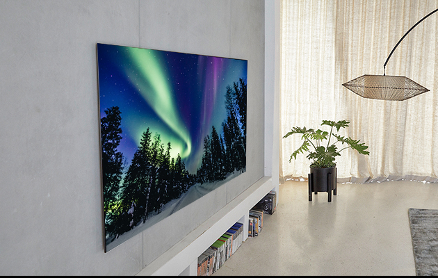 OLED on näyttävä lisä seinällä OLED-TV kiinnitettynä olohuoneen seinään. Televisiossa kuva revontulista.