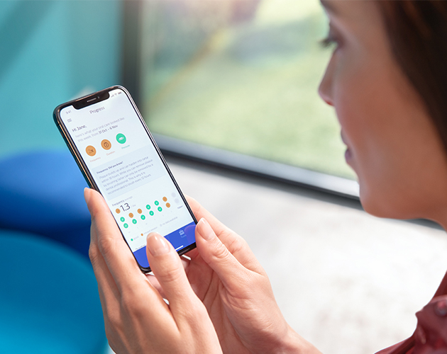 Sonicare-sovellus Nainen katselee sovellusta älypuhelimella