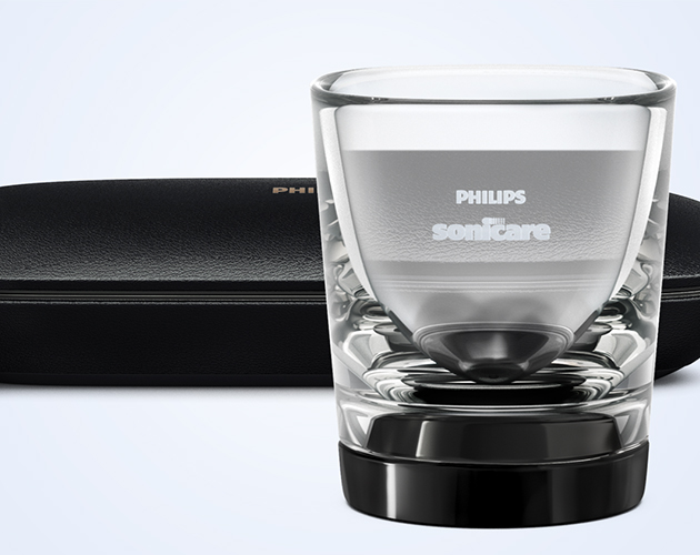 Pitkä akunkesto Philips Sonicare -logolla varustettu juomalasia muistuttava laturi ja musta matkakotelo