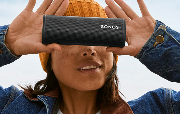 Kannettavassa Sonos Roam -älykaiuttimessa on sekä Bluetooth- että WiFi-yhteys Sonos Roam naisen kasvojen edessä