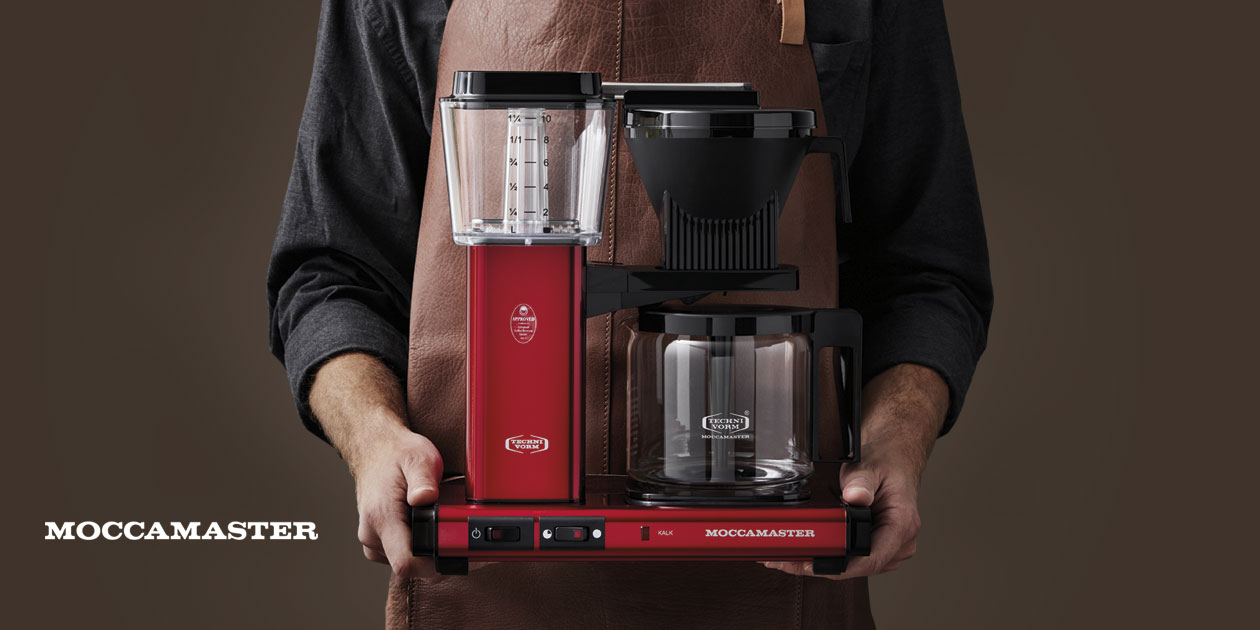 Moccamaster Mies joka pitelee Moccamaster-kahvinkeitintä