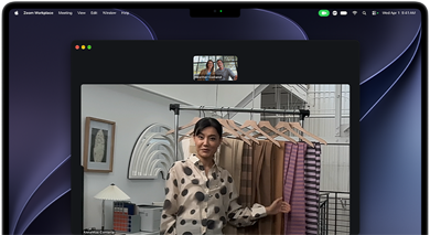 MacBook Prossa videopuhelu, jossa nainen esittelee kankaita kahdelle puhelun osallistujalle, valokeilatoiminto pitää hänet kuvan keskellä, kun hän liikkuu paikasta toiseen