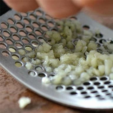 Valkosipulipuristin kädensijalla
