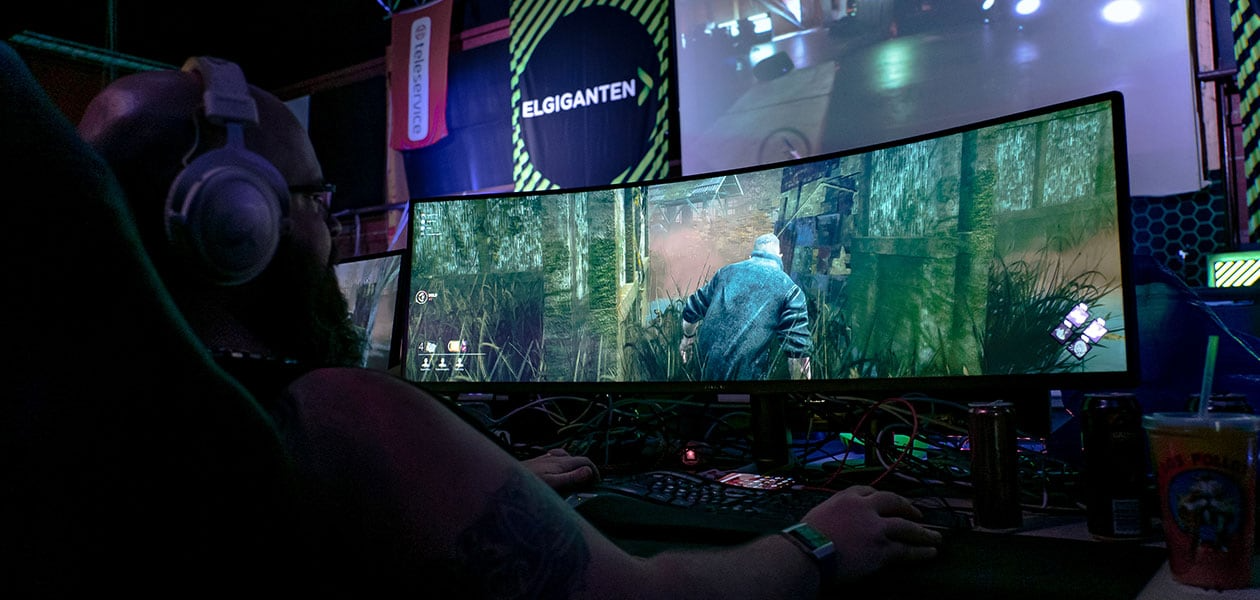 Gaming - Gaming PC - Pelaaja pelaa kaarevalla näytöllä