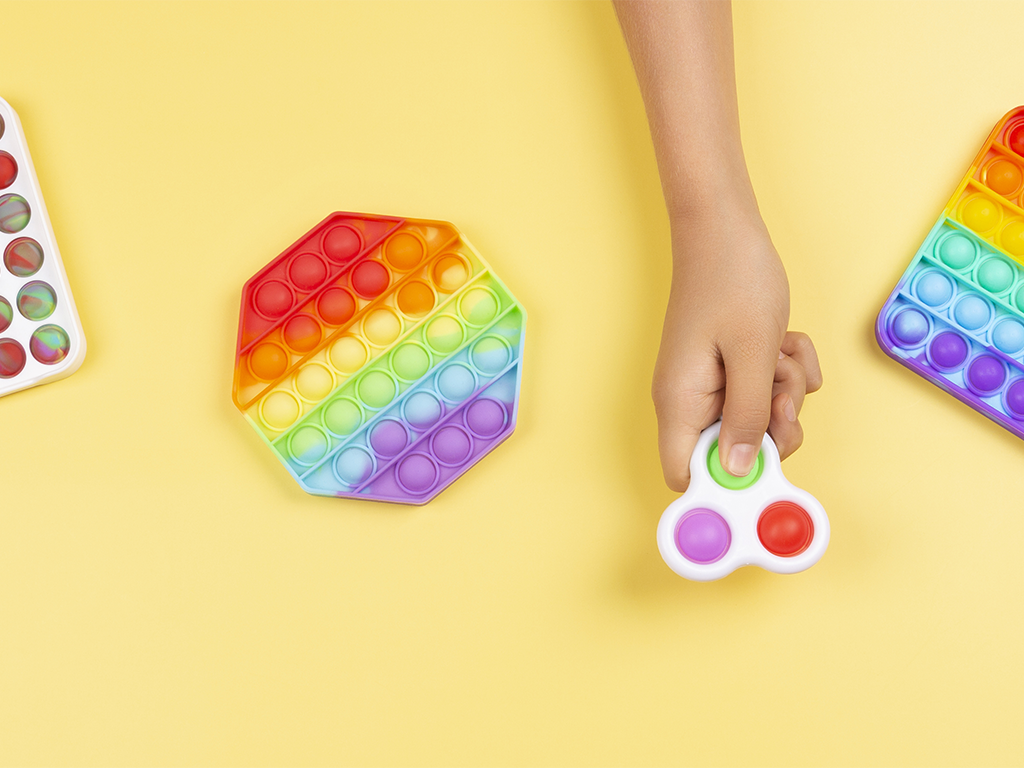 Erilaisia värikkäitä fidget toys -leluja, kuten fidget spinner ja pop it fidget -lelut