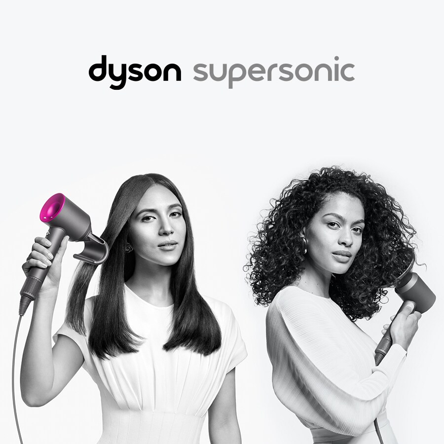 Kaksi naista kuivaa hiuksiaan Dyson Supersonic-hiustenkuivaimella