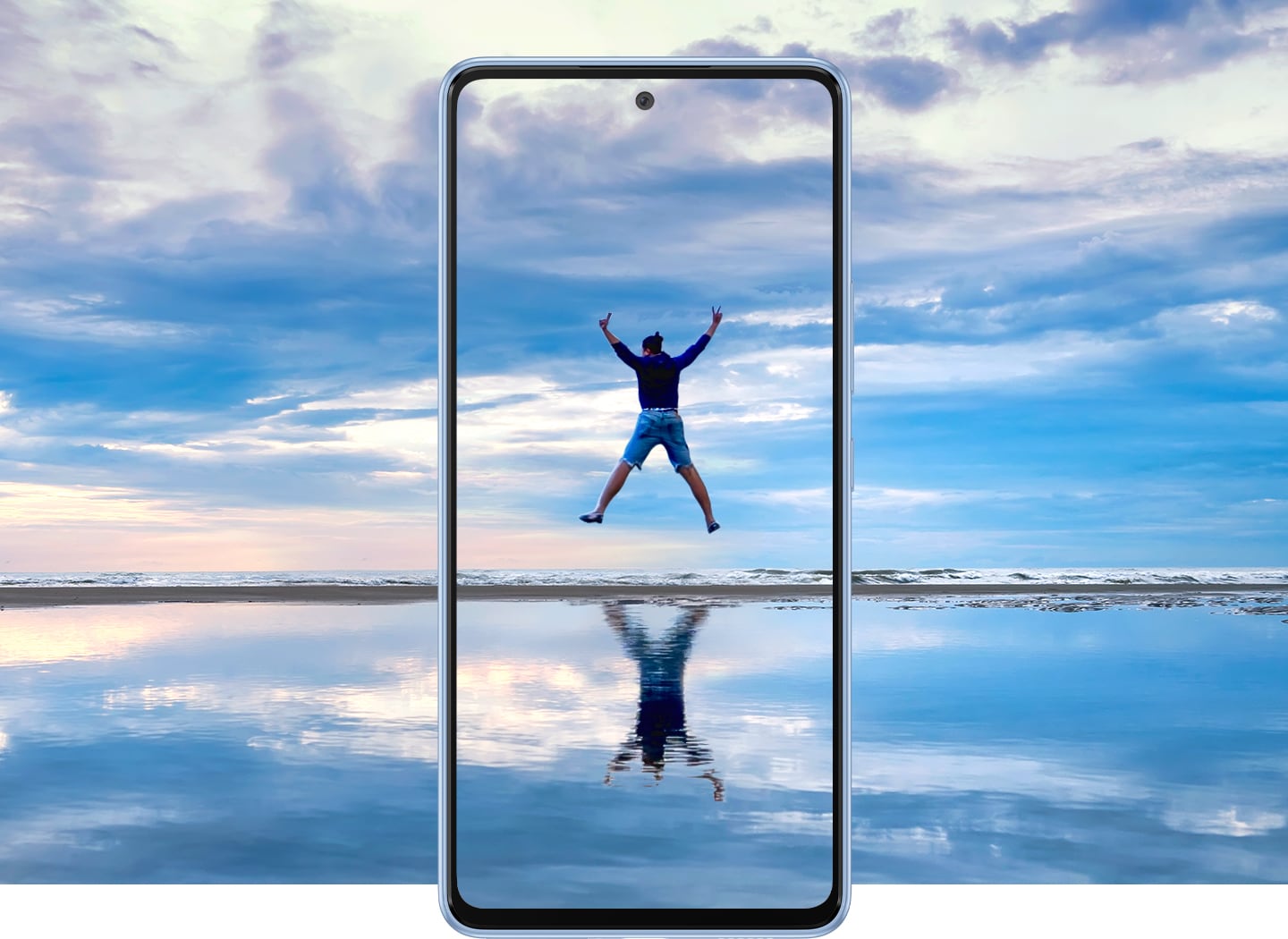 Samsung Galaxy A53 -näytöllä mies hyppää merimaisemassa, sama maisema jatkuu puhelimen kehyksien ulkopuolella