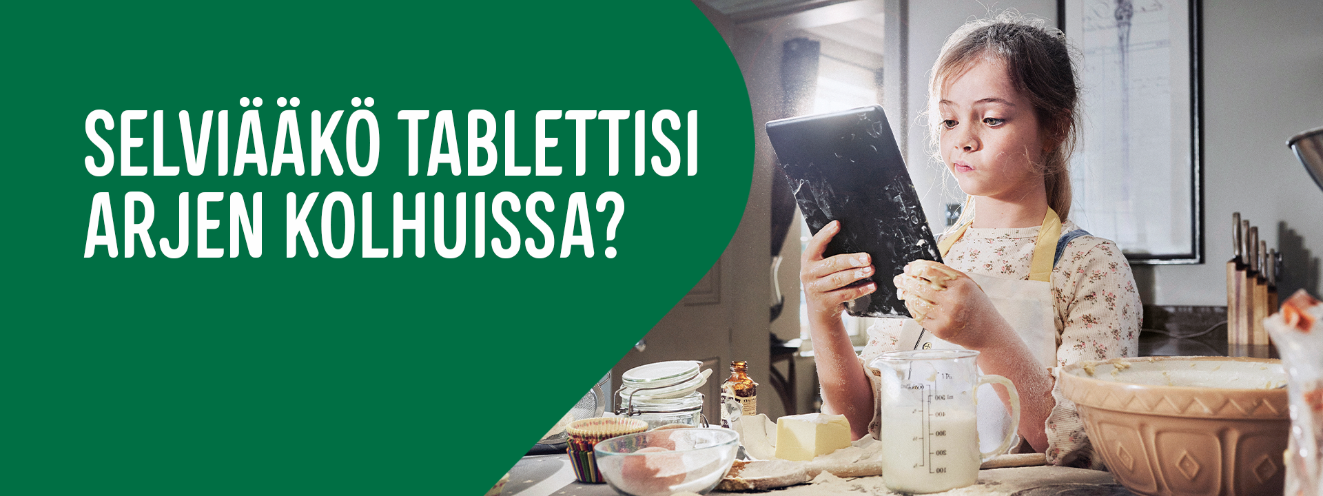 Tabletti ja vakuutus - tyttö katselee reseptiä tabletilta leipoessaan 