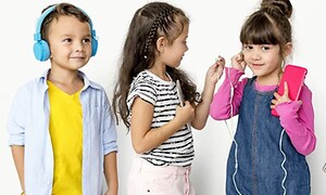 Pojalla korvakuulokkeet ja kahdella tytöllä omat puhelimet ja yhteiset nappikuulokkeet
