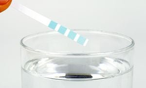 Veden kovuuden testaaminen testiliuskalla, jossa on raitoja sinisen eri sävyissä