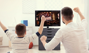 isä ja poika hurraamassa konserttia televisiota katsellen