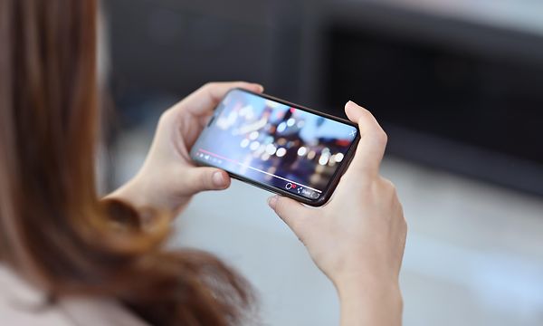 Nainen katsoo elokuvaa puhelimellaan