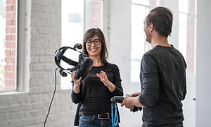 nainen selittämässä miehelle kädessään VR-lasit