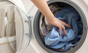 Pyyhkeitä asetetaan pyykinpesukoneeseen