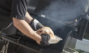Mies savustaa lihaa grillillä