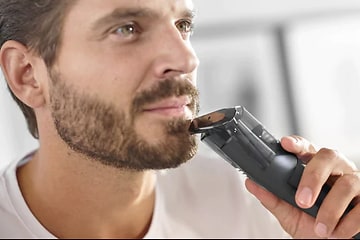 Mies trimmaamassa partansa Philips Series 7000 -trimmerillä