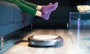 Robotti-imuri puhdistamassa likaista olohuoneen lattiaa