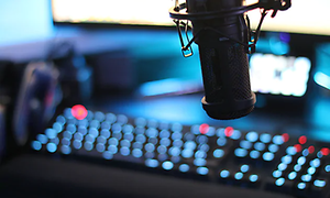 Studio, jossa mikrofoni ja runsaasti valaistuja painikkeita