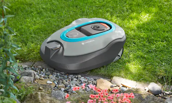 Gardena Sileno -robottiruohonleikkuri leikkaa ruohoa kukkaistutuksen läheisyydessä