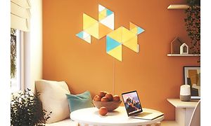 Keltainen, sininen ja oranssi Nanoleaf oranssinvärisessä huoneessa
