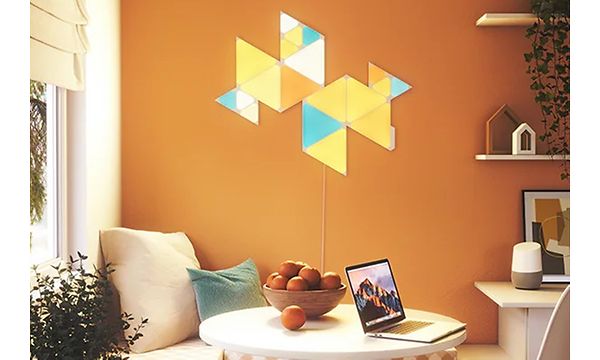 Keltainen, sininen ja oranssi Nanoleaf oranssinvärisessä huoneessa
