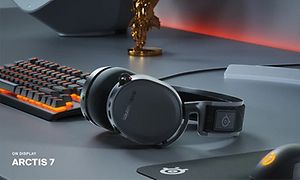 SteelSeries Arctis 7 pöydällä pelitietokoneen ja pokaalin vieressä
