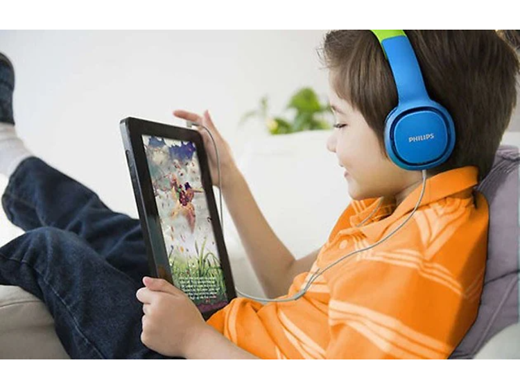 Lapsi käyttää tablettia kuulokkeet päässään