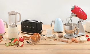 Valikoima eri värisiä Smeg-keittiökoneita keittiön työtasolla elintarvikkeiden vieressä