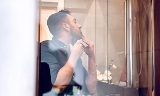 Mies ajaa partaansa kylpyhuoneen peilin edessä