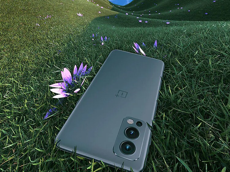 OnePlus Nord 2 smartphone laying in the grass next to a flower