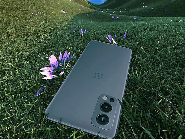 OnePlus Nord 2 smartphone laying in the grass next to a flower