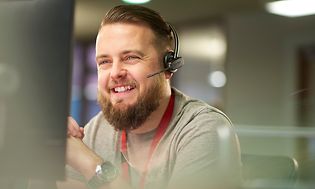 Hymyilevä mies kuulokemikrofoni päässään