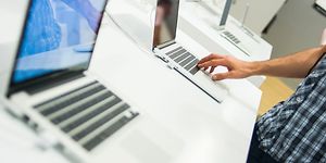 Henkilö tutustuu kannettavaan tietokoneeseen kaupassa