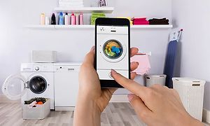 Henkilö käyttää pesukoneohjelmasovellusta älypuhelimellaan