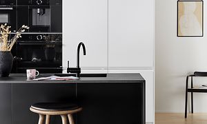 Moderni keittiö mustan ja valkoisen väreissä, jossa integroidut kodinkoneet