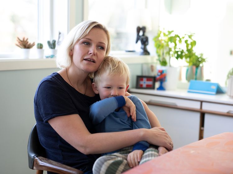 Äiti ja lapsi istuvat pöydän ääressä