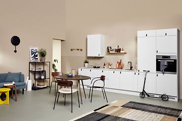 Valkoinen EPOQ Core -keittiö avokeittiöratkaisulla sekä sohva ja ruokailupöytä
