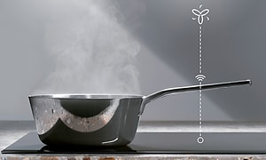 Kattila keittotasolla, jonka ylle on kuvitettu Hob2Hood-toiminnon langaton yhteys liesituulettimeen