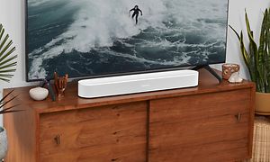 Sonos Beam 2 -soundbar ja TV-ruudulla näkyy lainelautailija