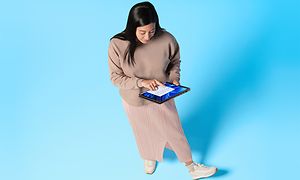 Nainen pitelee Windows 11 -kannettavaa