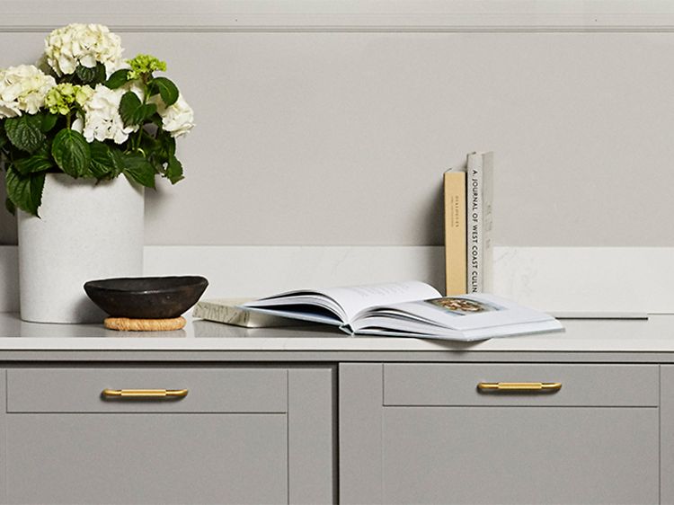Harmaat keittiökaapit ja Silestone Calcatta Gold -työtaso